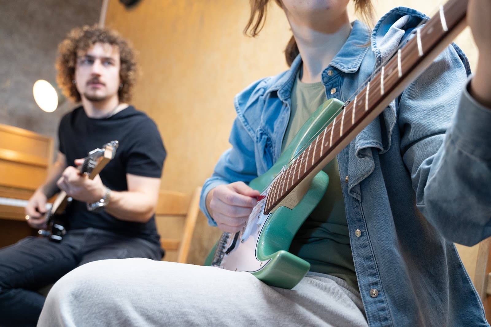 Zwei Erwachsene spielen gemeinsam Gitarre im Studio des Toro Musikinstituts